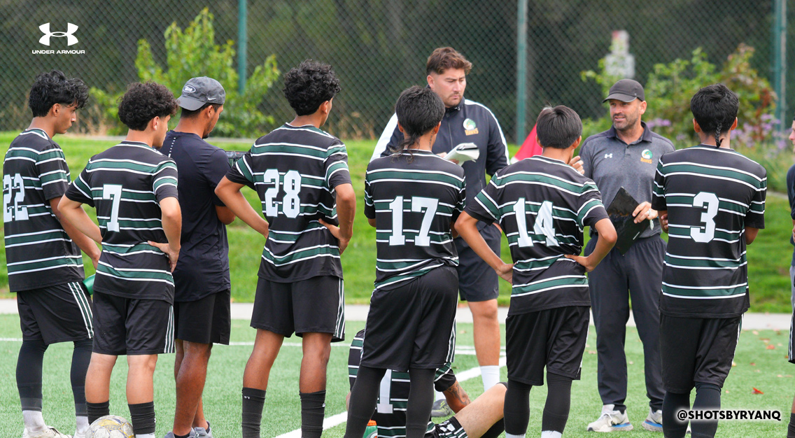 team of soccer players with back to camera in black jerseys with white numbers